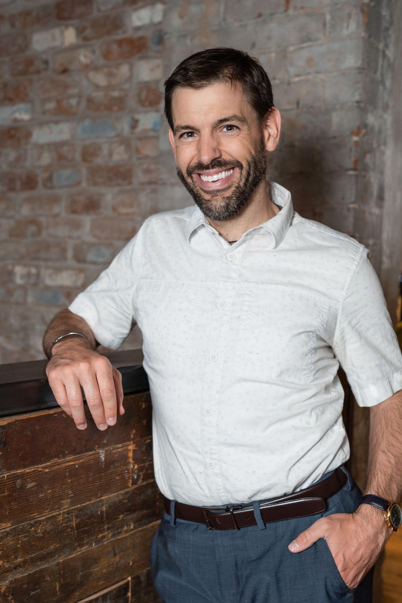 Dr. Clint Mausser leaning against a brick wall