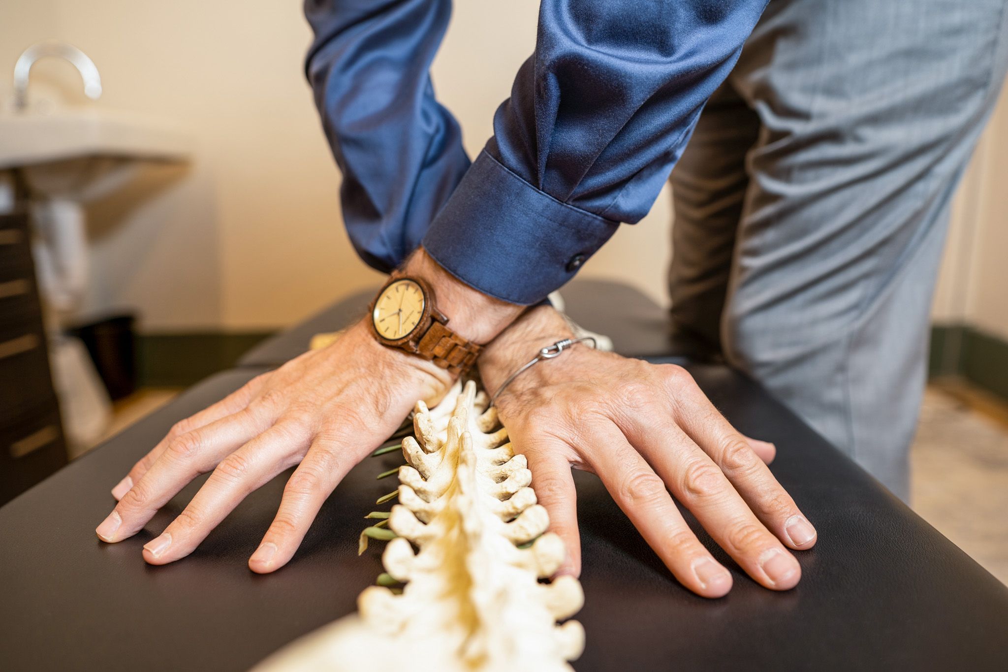 Chiropractor's hands positioned on a spine model